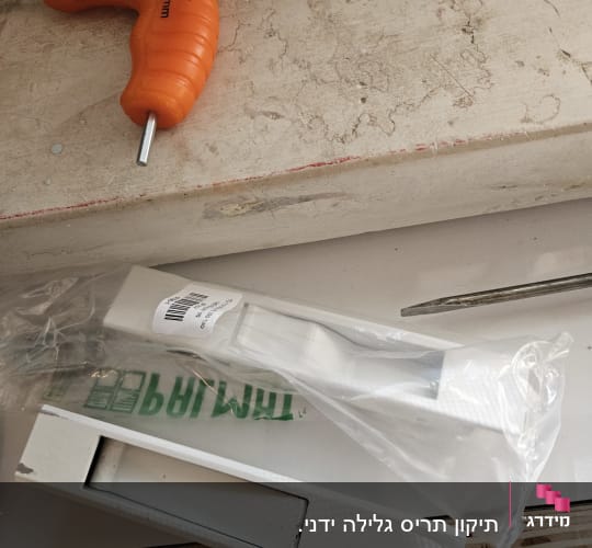 חלקי תריסים לבנים באריזת פלסטיק על שולחן